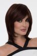 Woman in a shoulder length dark brown wig with long feathered layers and side bangs