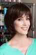 Woman in a shoulder length dark brown wig with long feathered layers and side bangs