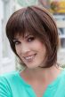 Woman in a shoulder length brown wig with long feathered layers and side bangs