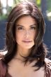 Woman in a past the shoulders dark brown wig with long layers