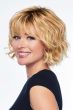 Woman in a shoulder length dark blonde wavy wig with fringe bangs