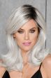 Woman in a past the shoulders silver-white wig with long bangs and dark roots