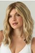Woman in a just past the shoulders light ash brown wavy wig with long side-swept bangs and dark roots