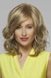 Woman in a chin length warm blonde curly wig with side bangs