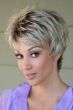 Woman in a choppy light brown pixie wig with fringe bangs