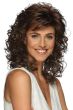 Woman in a past the shoulders dark auburn curly wig with wispy side bangs