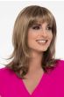 Woman in a just past the shoulders light brown wig with long layers and fringe bangs