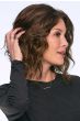 Woman in a shoulder length dark auburn curly lace front wig