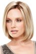 Woman in a shoulder length light blonde lace front bob wig with curled under ends and dark roots