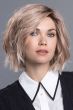 Woman in a past the chin tousled light brown razored bob wig
