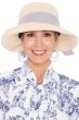 Woman in soft hand crocheted white summer brimmed hat with blue ribbon for cancer patients