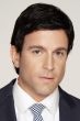 Man in a in a close cropped dark brown pixie wig