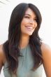 Woman in an extra long dark brown layered wig with long side bangs
