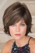 Woman in a chin length textured medium brown bob wig with choppy layers and side bangs