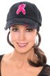 Woman in black baseball cap with pink breast cancer ribbon on the front