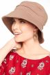 Woman in khaki wide brim pleated UPF sun hat for cancer patients
