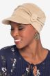 Woman in beige cotton newsboy style hat for cancer patients with pleats and side button