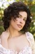Woman in a shoulder length curly dark brown lace front layered wig