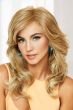 Woman in a large extra long curly warm blonde wig with side bangs