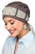 Woman in taupe turban with scarf looped through the head covering