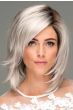 Woman in a shoulder length platinum blonde choppy layered wig with side bangs