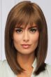 Woman in a large past the shoulders medium brown blunt cut wig with blunt bangs