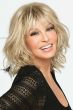 Raquel Welch in a wavy light blonde shoulder length wig with long choppy bangs
