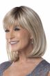 Woman in a large chin length light blonde straight wig with fringe bangs