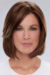 Woman in a shoulder length medium auburn wig with long side bangs