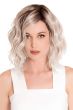 Woman in a chin length platinum blonde wavy wig with dark roots