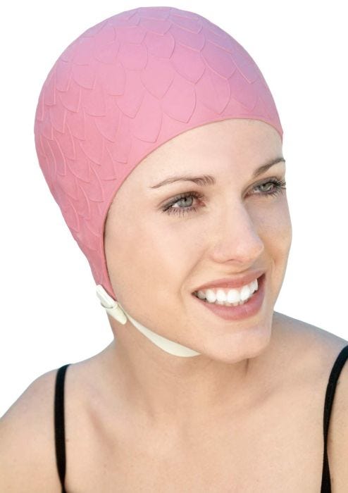Woman in pink molded rubber swim cap with textured leaves and chin strap