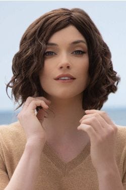 Woman in a shoulder length medium auburn curly lace front wig