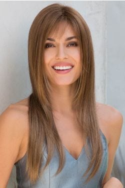 Woman in an extra long light brown wig with face framing layers and wispy bangs