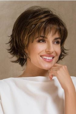 Woman in a large chin length dark brown bob with choppy layers and wispy bangs