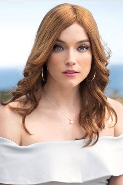 Woman in an extra long light auburn curly human hair wig
