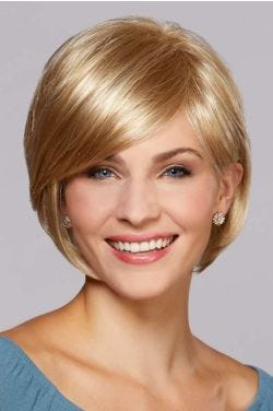 Woman in a chin length light gold blonde bob wig with long side bangs