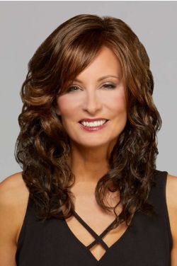 Woman in a past the shoulders dark brown curly lace front wig with side bangs
