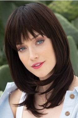 Woman in a past the shoulders dark brown wig with textured bangs and face framing layers