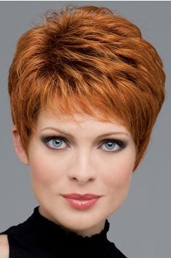 Woman in a copper red classic pixie wig with longer layers on top and fringe bangs
