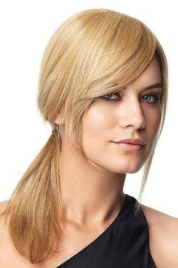 Woman with long face framing dark brown bangs attached to her biological hair