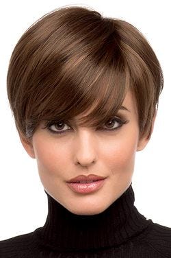 Woman in a long medium brown pixie wig with side swept bangs and shorter hair in back