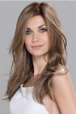 Woman in an extra long light brown straight human hair/synthetic blend wig