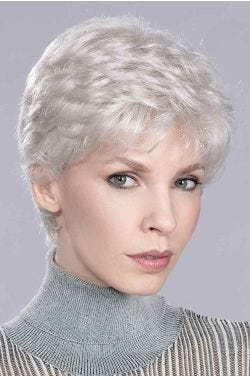 Woman in an evenly layered curly light blonde lace front pixie wig