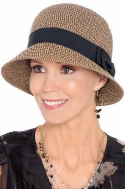 Woman in cloche style summer straw hat with black band and brim