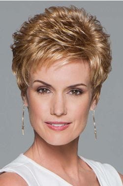 Woman in a strawberry blonde pixie wig with curled spiky layering on top and fringe bangs