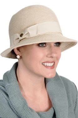 Woman in a white summer cloche brimmed straw hat with bow on the side