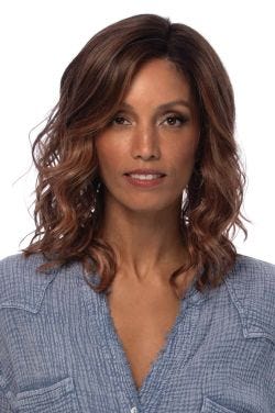 Woman in a shoulder length platinum blonde lace front wig with beach waves and dark roots