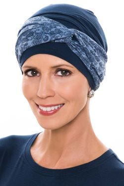 Women in navy chemo turban with blue print twist headband over the top