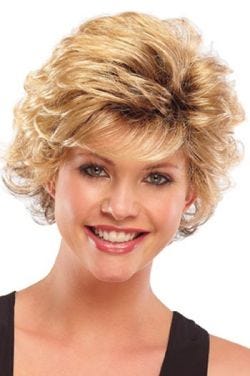 Woman in a long strawberry blonde pixie wig with longer layers on top and side bangs