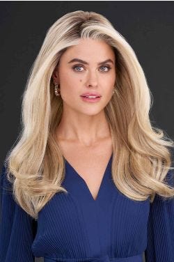 Woman in long, wavy strawberry blonde wig with with long side-swept bangs framing the face